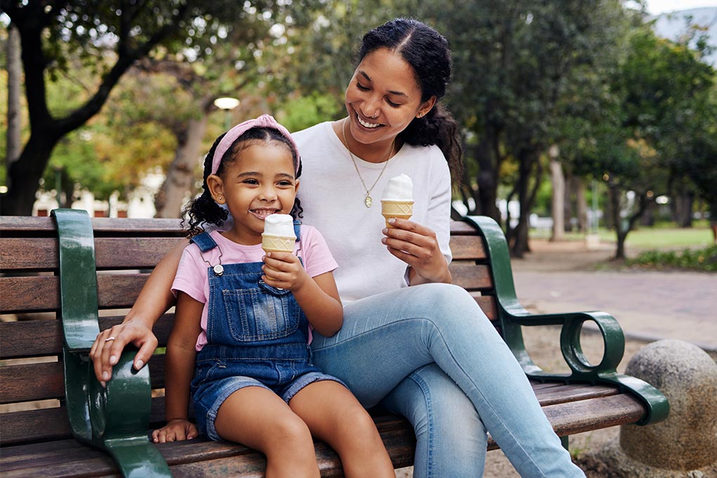 Parent and Child Enjoying Ice Cream on Park Bench