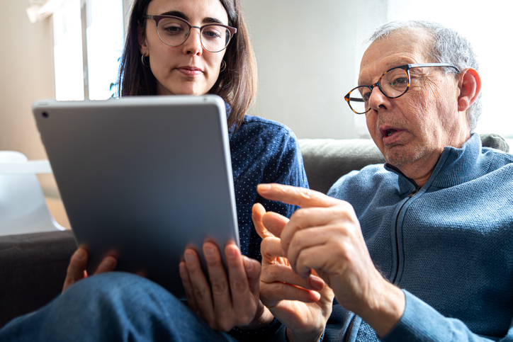 Older man and younger woman holding tablet